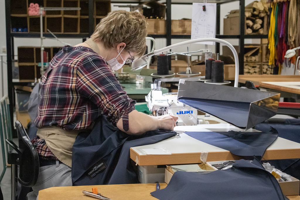 Une couturière assemble les pans de tissu pour former le parapluie.
